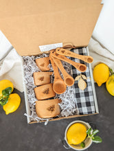 Load image into Gallery viewer, gift box containing- measuring cups, measuring spoons, dishtowel, and lemon shaped wooden magnet 
